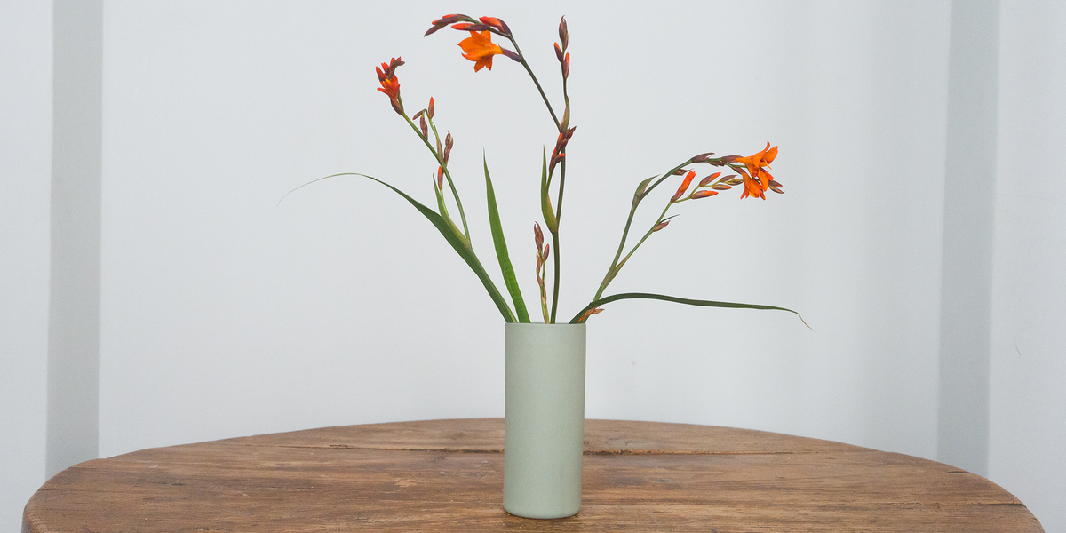 Grüne handgemachte Porzellanvase mit Blumenstrauß