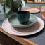 Midnight moss dark bottle green porcelain coffee cup on a set of hadmade porcelain bowls and plates in pastel colours. Handmade in Berlin.